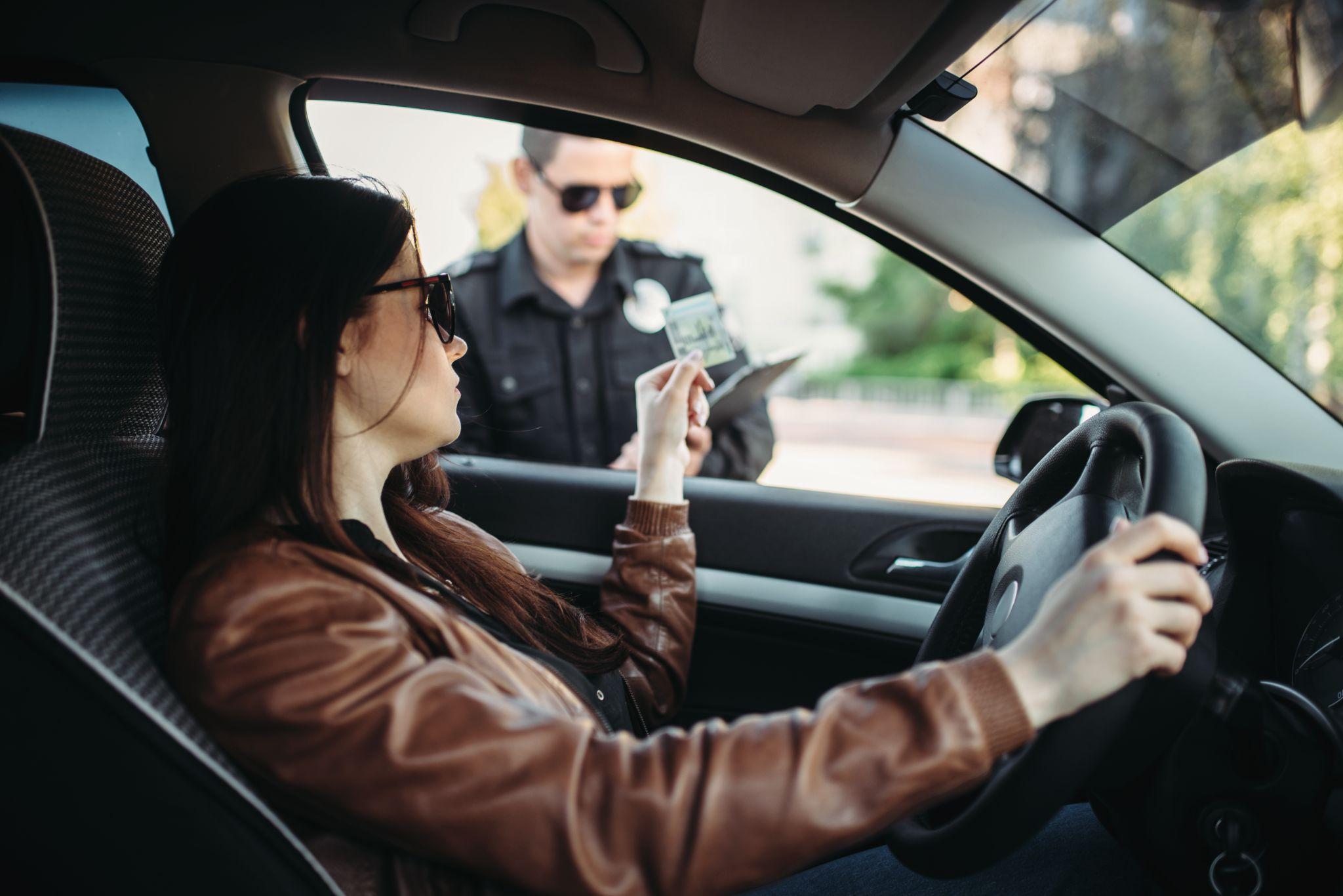 Male cop in uniform writes a fine to female driver